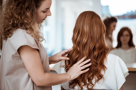 female-hairdresser-making-hairstyle-redhead-woman-beauty-salon_176420-4476