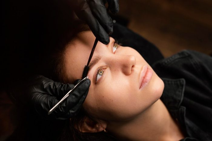 high-angle-female-clinician-doing-eyebrow-treatment-female-customer_23-2148846015
